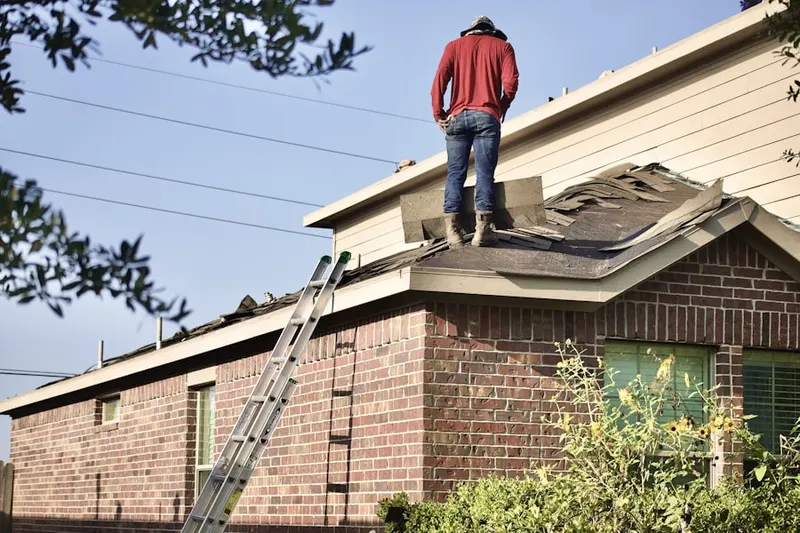 Professional roofer working on a residential roof in North Andrews Garden